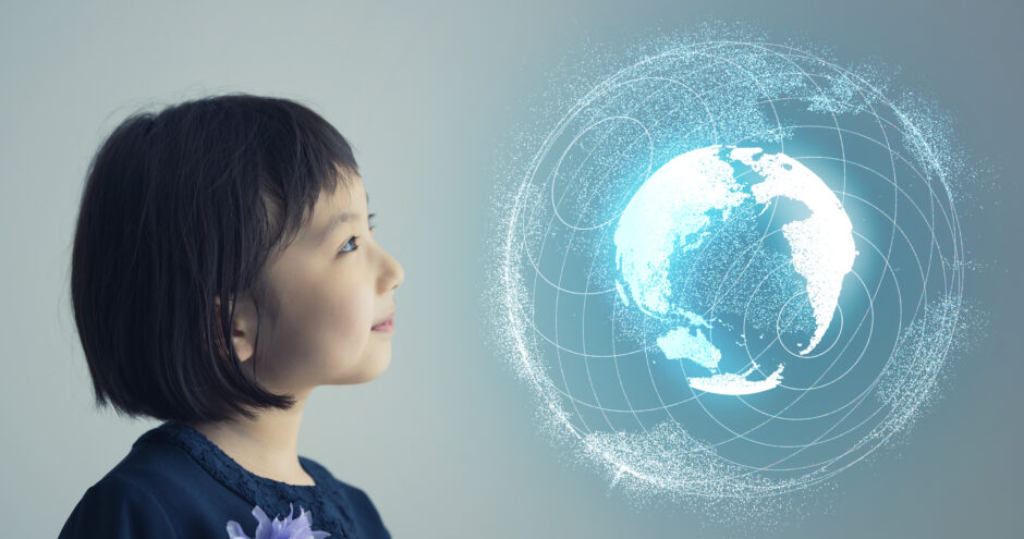 小学生くらいの女の子が地球の模型を眺めている。