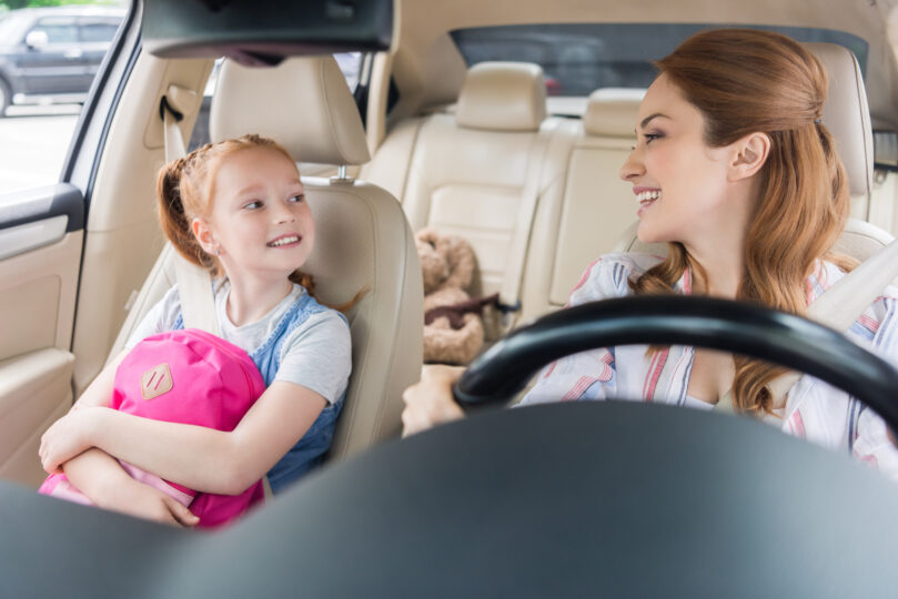 母親が運転する車の助手席に娘が乗っている。