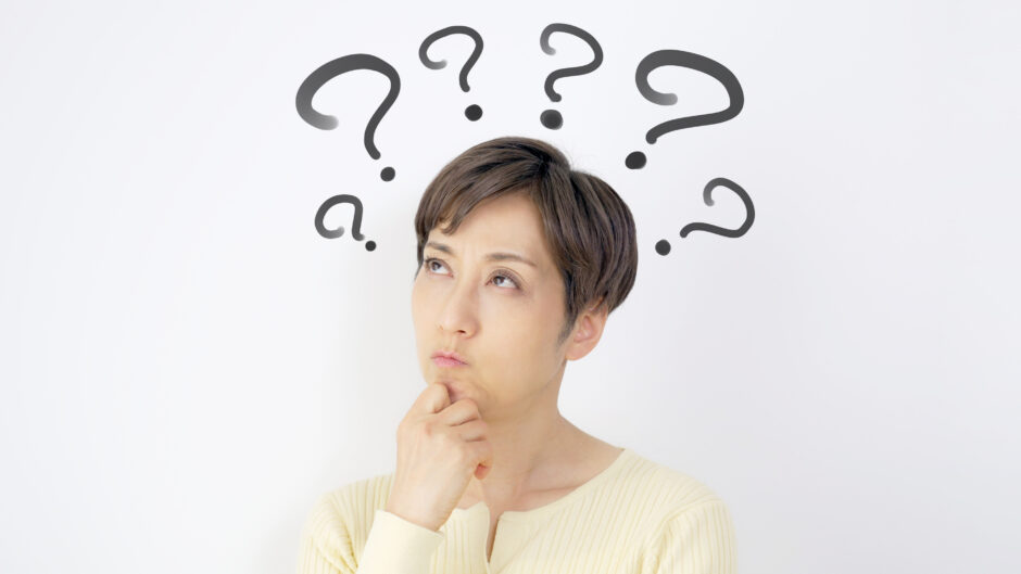 中年のアジア人女性が考え事をしている。