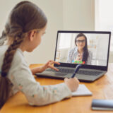 小学生の女の子がオンラインでレッスンを受けている。