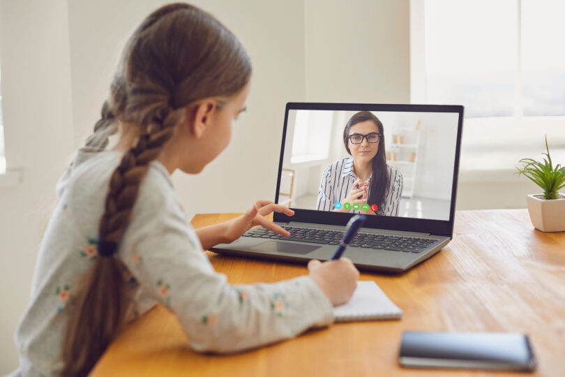 小学生の女の子がオンラインでレッスンを受けている。