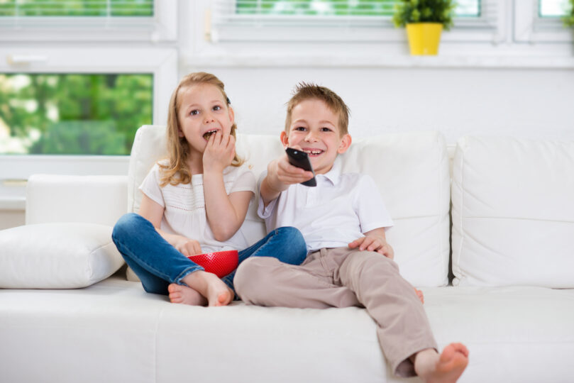 兄と妹がリビングでテレビを見ている