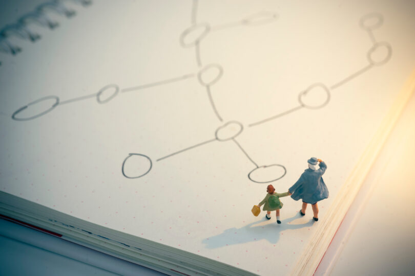 母親と子どもの形をした小さな人形が紙の上に置いてある。