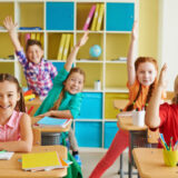 小学校の子どもたちがクラスで楽しそうに授業を受けている