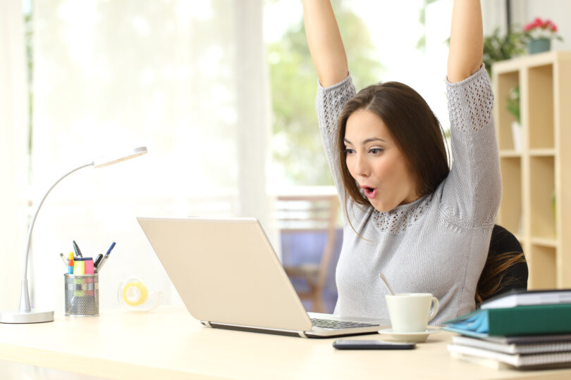 女性がインターネットで合格を確認し、大喜びしている。
